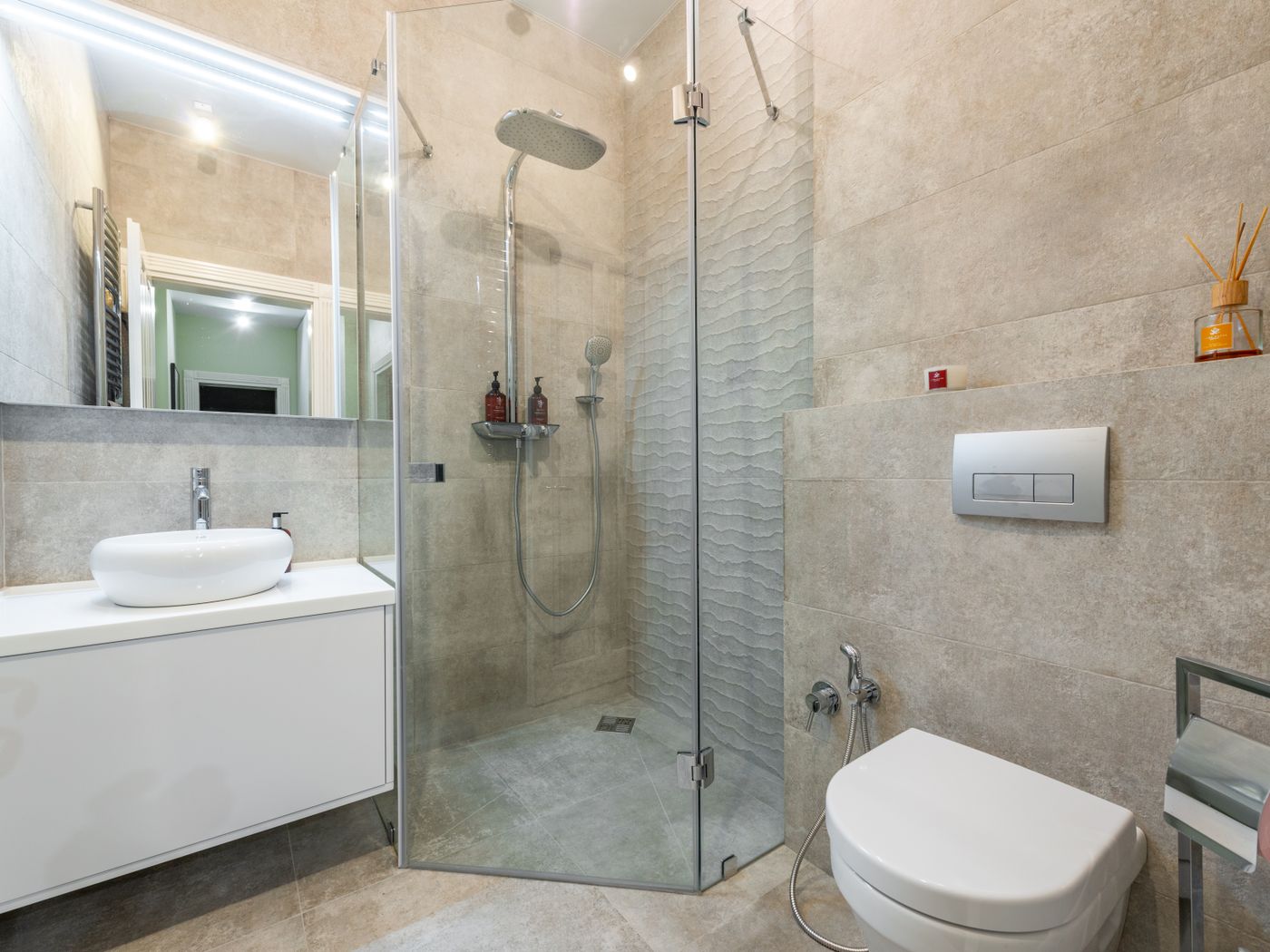 Finished ensuite with a glass shower enclosure, wall-hung toilet and vanity basin